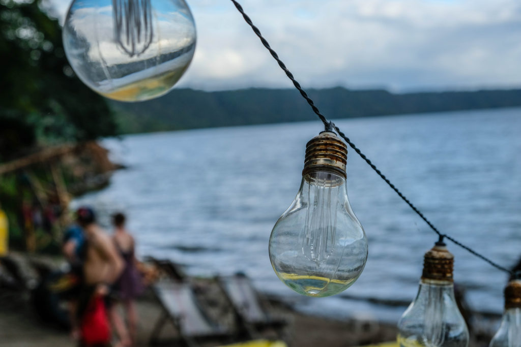 Lightbulbs hang over the tables at the beach restaurant at Hostel Paradiso