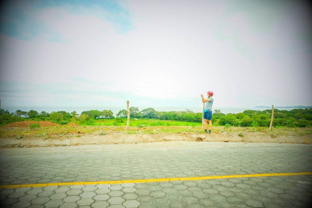 Dennis taking photos of Lago Cocibolca while standing next to the road