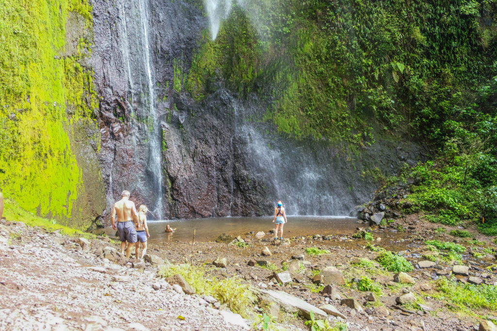 Horizontal image of the San Ramon Waterfall showing people swimming in the pool below