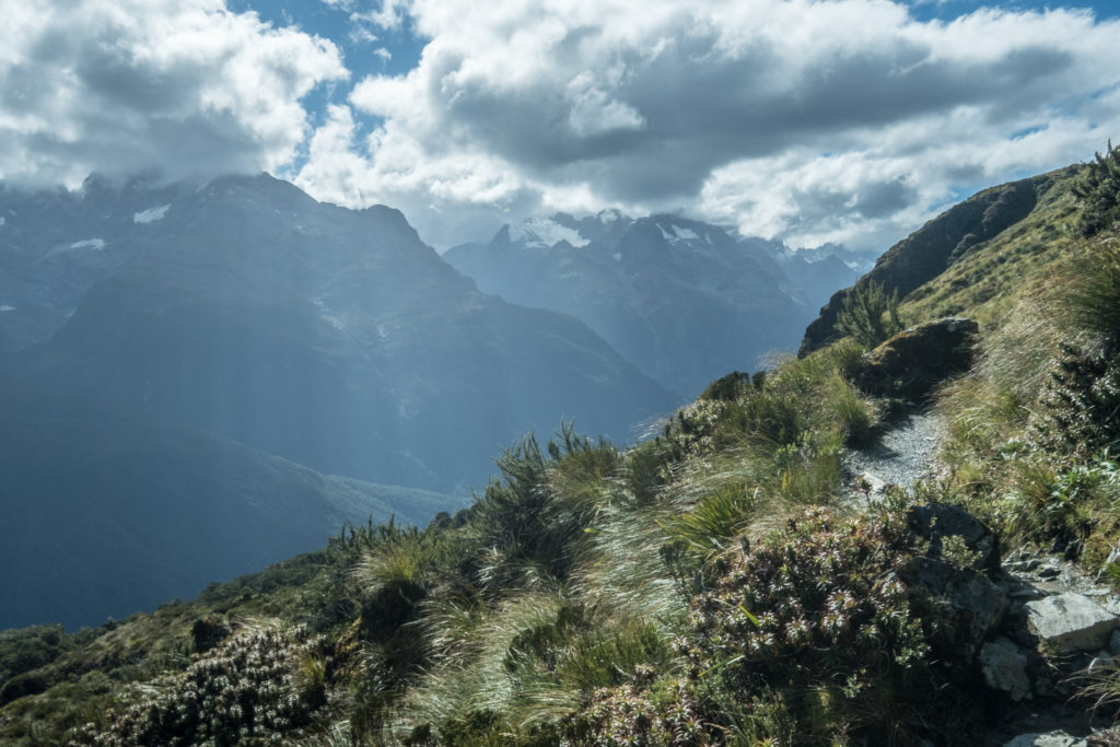 Sun peeking through the clouds over the Hollyford Valley